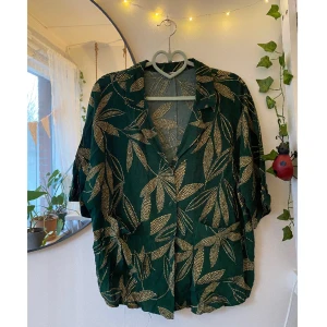 Kortärmad mönstrad skjorta  - Superfin tunn, kortärmad grön skjorta från Mango med löv. Oanvänt skick. Skriv om du har frågor :)