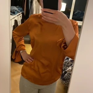 Orange topp  - Silkes orange topp långärmad storlek s / 34