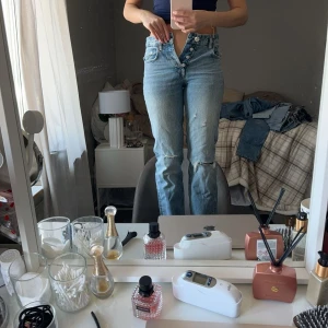 Zara - Mid waisted zara jeans med hål i knäna, använt 2 gånger. 