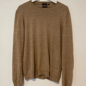 Oscar Jacobson tröja - Säljer nu min riktigt snygga Beiga Oscar Jacobson tröja som är gjord av 100% bomull. Riktigt bra skick har bara använts ett fåtal gånger och har inga defekter. Storleken är S men kan passa M. Har ni frågor så ställ dem gärna!  