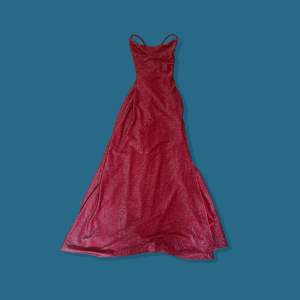 Röd stretchig glittrig balklänning med justerbara band i ryggen som gör att den passar från XS till M. Längd: 132 cm, Midja: 60 cm.