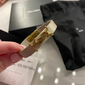 Ysl armband - Säljer nu mitt superfina ysl armband jag fick (nytt) förra julen!❤️I mycket bra skick bortsett från en liten fläck (som man ej ser när man har på sig det), man kan se den i bild 3❤️Dustbag, låda och äkthetsbevis medkommer vid köp! Nypris 3220kr.Storl M