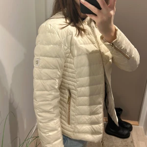 Rockandblue vårjacka  - En supercoola ljusbeige vårjacka med guldiga detaljer från Rockandblue! Använd väldigt sparsam, inga tecken på slitage. Nypris ligger på runt 2000kr 