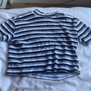 Vit,grå och svart randig t-shirt.storlek 140 i barn kommer ifrån Ullared 