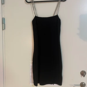 Klänning - Svart klänning med små diamanter på banden. Går att använda till nått simpelt men även festligt.