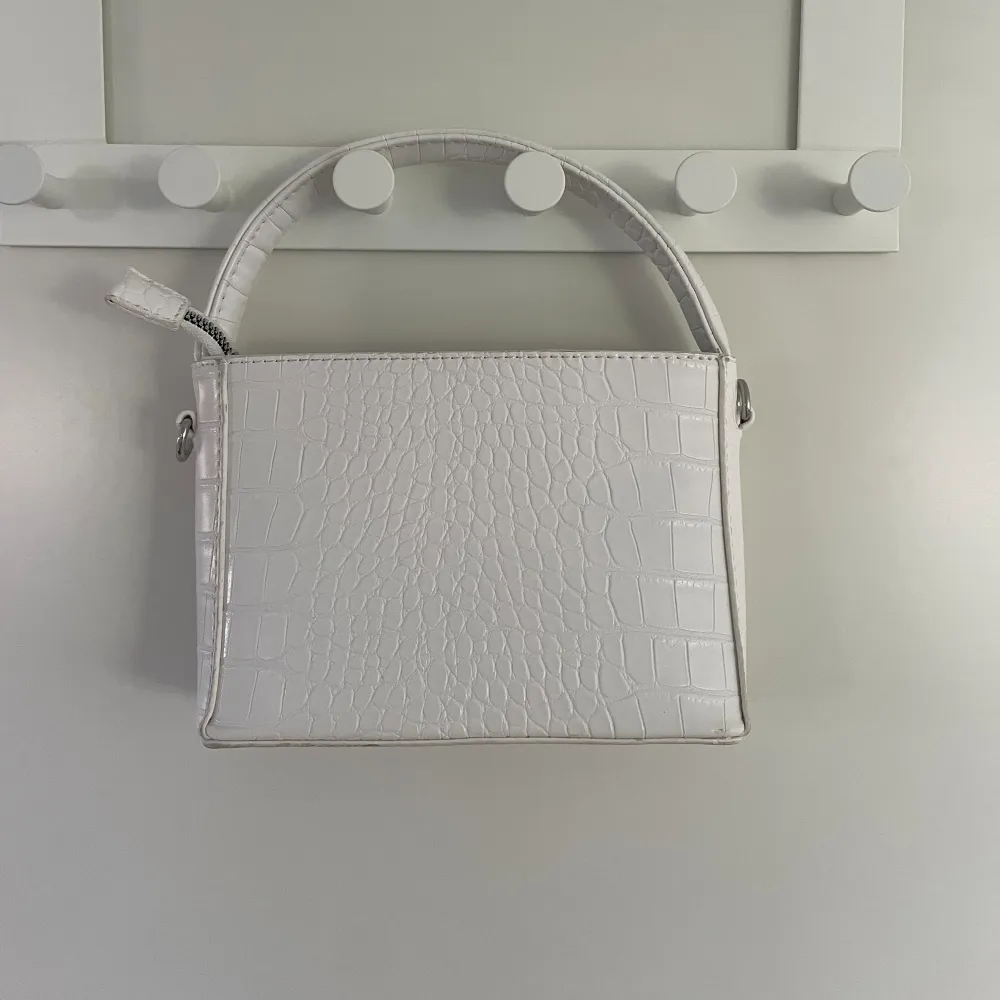 Säljer denna vita handväska 🤍 fin kvalité, kommer endast med det korta bandet till . Väskor.