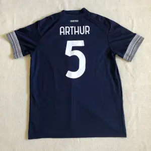 Säljer Juventus bortaställ från säsongen 20/21 med den brasilianska mittfältaren Arthur på ryggen. Tröjan är äkta och i mycket bra skick då den inte har några skador eller defekter. Tveka inte på att höra av dig vid minsta fråga eller fundering! 