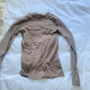 En brun långärmad tröja från hm. I ett slags ribbat material 