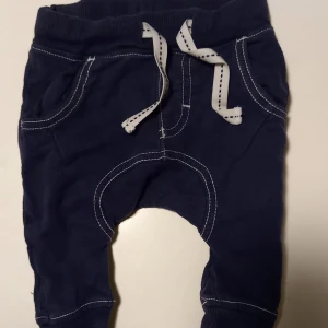 Byxa/"jeans" strl. 56 - Byxa/"jeans" byxor med vita sömmar i storlek 56 från Kappahl. Är märkta med storlek 62 men är små i storleken, femte bilden visar en jämförelse med ett par byxor från Newbie i storlek 56. I fint begagnat skick, inga hål eller fläckar, men blekare än