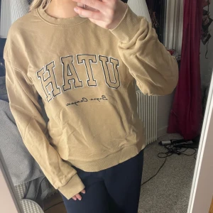 Collegetröja - En beige collegetröja som det står Utah på. 