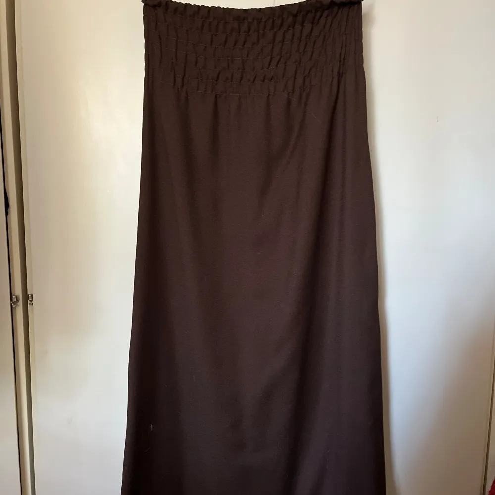 En brun lång kjol med smock upptill som är i bra skick. Kjolar.