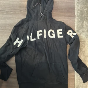 Tommy Hilfiger Hoodie - Använd ett par gånger. Passar Stl. S och M. Lite slitage på trycket på ryggen. Nypris 1000kr