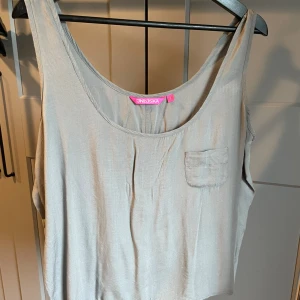 Ljusgrå topp - Linne/topp från indiska. Tunt tyg med ficka på bröstet. I använt skick. Storlek S