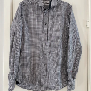 Svart och vit rutig skjorta från Stenströms strl 37, modell slimline - Svart och vit rutig skjorta från Stenströms strl 37, modell slimline.  Endast använd vid ett tillfälle och är i fint begagnat skick.  Mått Över bröstet: ca 49 cm Längd från axeln och ner: ca 72 cm  100% bomull 