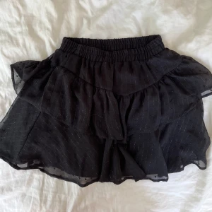 Svart volangkjol - Denna volangkjol är kort och lite skimrig om man kollar noga, helt ny med prislapp på!!💕