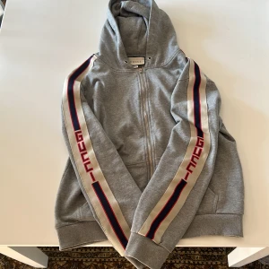 Gucci tröja zip hoodie - Hej, säljer nu min Gucci tröja då den bara tar plats i garderoben, storleken är L men den passar bra på mig som är 176 cm och även dom som är lite längre. Fick den i present så har inte något äkthetsbevis därav priset. Skriv om de är nått ni undrar☺️
