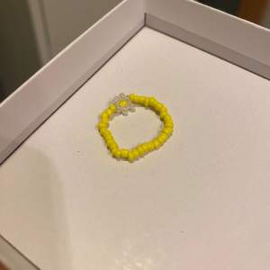 En söt gul ring med vit blomma av pärlor! Fint skick
