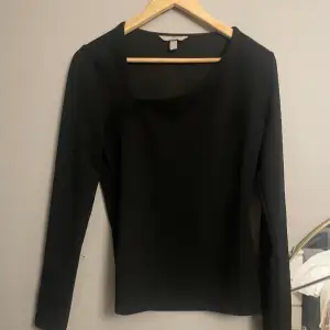 En svart tröja med lite snedskuren bringa, materialet känns lite lyxigare, lite tjockare. Den är knappt använd och är i toppenskick! Skriv för fler bilder💕
