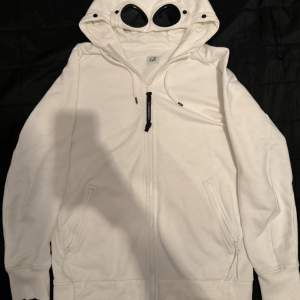 Tjo, en grymt snygg vit cp company hoodie till ett grymt bra pris. Hoodien är använd fåtal gånger och har inga skador eller annat. Kvitto finns! 