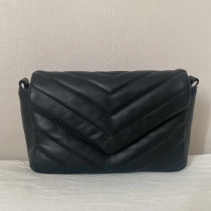 Väska  - En supersöt svart väska!! 💝💝 Kedjan är ca 120 cm lång och väskan är ungefär 20 cm lång. Kedjan har blivit lite rostig men inget man direkt märker av speciellt mycket. 🥰