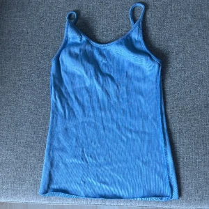 Blått linne med låg rygg - Jätte fint ljus blått linne med låg rygg. Plagget har inte kommit till användning för mig tyvärr. Plagget är avklippta i botten. 😊