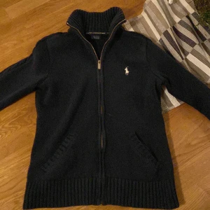 Ralph lauren tröja - Det är storlek small liten i storleken, tröjan själv har inga defekter men ”handtaget” på dragkedjan är av men skickas med annars är den i bra skick. Nypris; 2020kr ,mitt pris;525