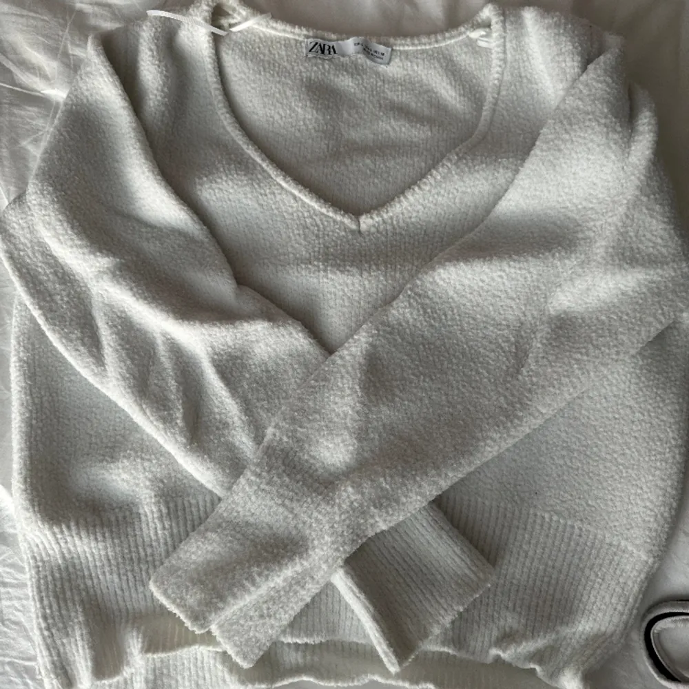 En vit stickad tröja som är väldigt liten i storleken, därav att jag köpte L(hade zs-s egentligen när jag köpte den). Använd därav priset. Den är även fin att ha bakomfram så v-ringningen är där bak.. Tröjor & Koftor.