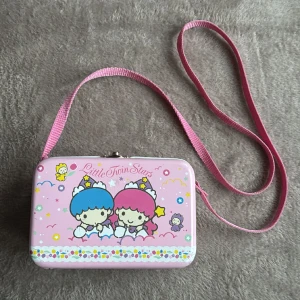 San rio väska - Söt väska från San rio i plåt. Retro från 1997. Axelband ca 1 meter långt så den hänger ner ca 50 cm från axeln. ”Little twin stars”. 