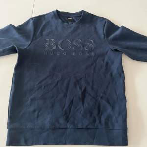 En mörk blå Hugo boss sweatshirt i storleken s och tröjan är i ett ganska bra skick