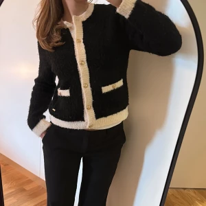 Kofta  - Svart vit kofta med guld knappar. Koftan är från LINDEX. Använd fåtal gånger. Fint skick. Storlek S. Skön och varm. 