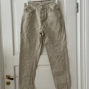Momjeans - Ljusbrun/beige/grå mom-jeans från Gina Tricot i storlek 38. Använda en gång, i fint skick. Bara att fråga om det är något du undrar! Kan mötas på Järntorget i Göteborg eller skicka, köparen står för frakt.