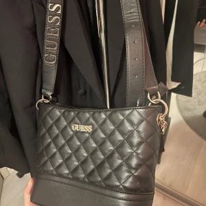 GUESS väska - En fin praktisk väska, äkta, den är i jättebra skick. Endast använd fåtal gånger. Inga skador på väskan och ser ut som ny🥰 nypris 1379kr, pris går att diskutera vid snabb affär 