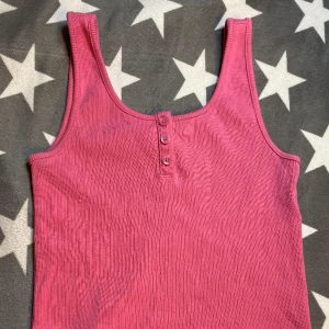 Sätt rosa linne från Gina tricot Young 💗💗 - Bra skick, på bilderna ser det ut som att det är ett havsliknande mönster men det är det ej. Linnet är dock ribbat. Kort linne så man visar magen lite, kan vara bra att veta. Säljer för att jag växt ur det. 