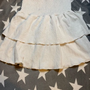 Vit volang kjol från Gina tricot Young  - Helt okej skick, en liten fläck som syns lite vid midjan men annars okej skick. Säljer då jag har växt ut den. 