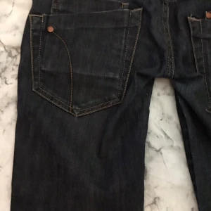 Svarta jeansbyxor - Ett par svarta jeansbyxor med fram- och bakfickor samt knapp och dragkedja. Byxorna har en fin passform och är i bra skick. Passar jätte fint med ett var höga boots eller klackar!