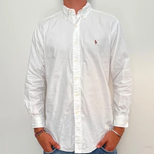 Ralph Lauren - Vit Ralph Lauren skjorta i storlek 15-32 vilket motsvara ca L. Skjortan är i fint skick med en jätteliten fläck på höger bröst (se bild). Modellen är 186 cm lång. Orginalpris ca 1500 kr och nu endast 499. 