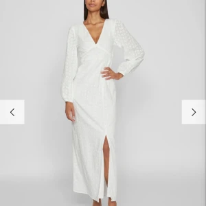 Vit långklänning - Superfin slutsåld klänning från Vila som liknar den populära Adoore klänningen! Helt ny med prislapp kvar!🤍🤍I material kallat broderie anglais, med vitt slätt innertyg vilket gör att den inte  blir   genomskinlig!