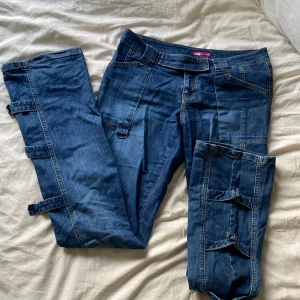 Jeans - Lågmidjade bootcut jeans med detaljer längst benen. Köp på vintage butik i Malmö men inte fått användning för.  Stl 36 men stretchiga material så passar även dig som har 38 eller större.