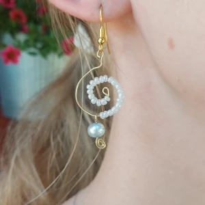 Örhängen med virvel och sten - Guldiga virvelörhängen med vita pärlor och blå sten🌊🌙  Kan skickas eller hämtas, vi står ej för frakt😇