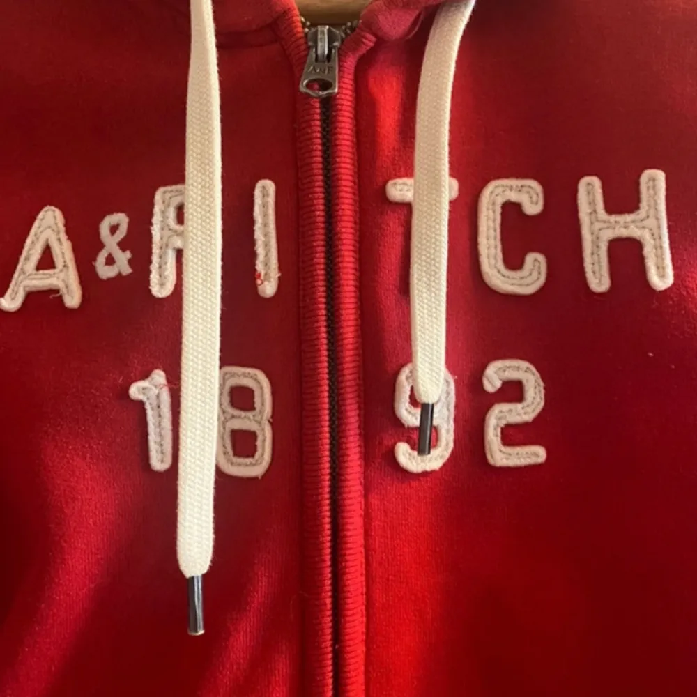 Superfin röd hoodie från Abercrombie & Fitch! Small Huva med grått foder  Fickor fram  Dragkedja  Snören  Allt toppenbra! . Hoodies.