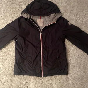 Moncler windbreaker - Sizen på den här varan är 14y 172-175cm. Den är i väldigt bra skick har använt den ungefär 10 gånger.