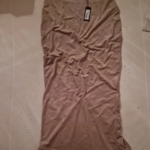 Kjol - Beige kjol med slits i bak. Helt ny med lapp kvar.  från nelly one stl s