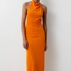 Orange långklänning - Superfin sommarklänning från Pull & Bear!🧡 Öppen i ryggen med justerbart band ifall man vill spänna/lossa runt midjan/bysten. Halterneck modell. Köpt i Kroatien och använd 1 gång.