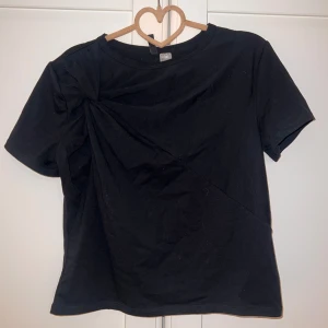 T-shirt  - En svart T-shirt med en fin detalj i storlek S från H&M.