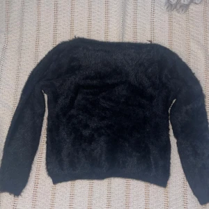 Svart tröja med fluffigt material  - Jättemjuk och skön tröja  Några trådar som sticker ut, se bild