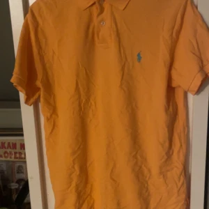 Ralph lauren pike - Orange ralph lauren piké med grönt tryck