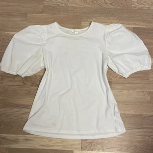 Blus - Vit blus med puffiga axlar. Aldrig använd så inga skador.