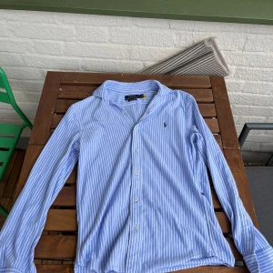 Ralph lauren skjorta - Snygg blå-vit randig Ralph lauren skjort till salu. Passar tyvvär inte mig och därför jag säljer vidare. Använd vid få tillfällen. Bra skick!  