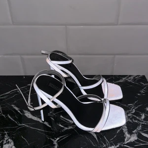 Reflex klackskor - Jag säljer mina riktigt coola klackskor med reflex material!! Köpta för 4 år sen, använda 1 gång.  Klackhöjden är 12 cm och skorna passar även folk med stl 37.  (Första och sista bilden är tagen med blixt)