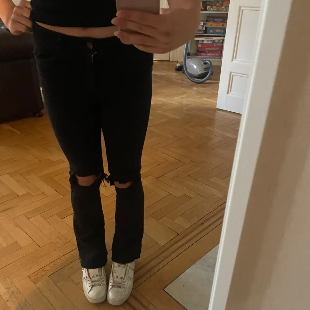 Säljer dessa ascoola svarta bootcut lowwaist jeans med hål! Inga defekter! Använt 1-2 gånger! Kan mötas upp eller posta!. Jeans & Byxor.